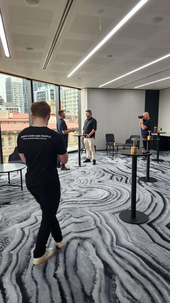 A behind-the-scenes look at a professional video shoot for a business in a modern office setting, showcasing the team at work for a Video Marketing Gold Coast project.
